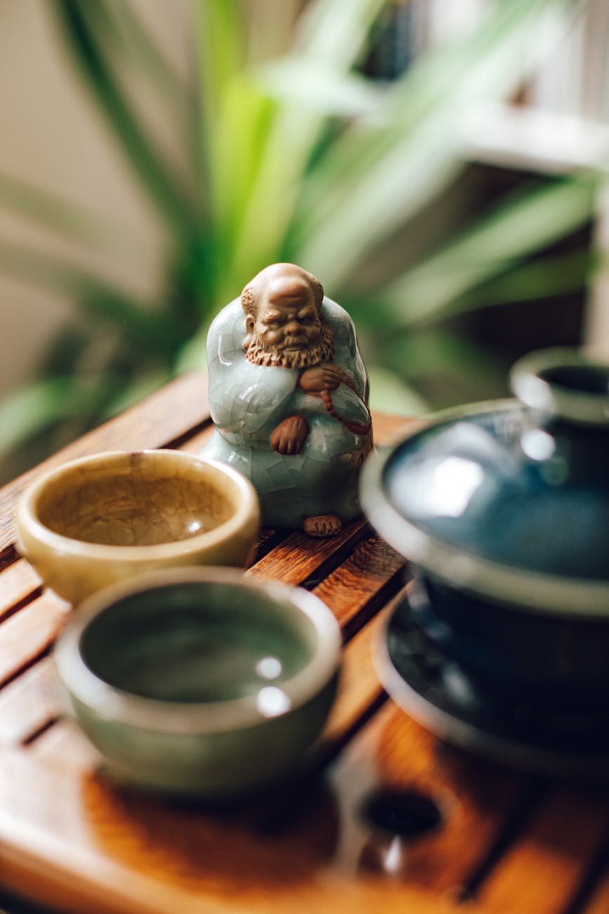 gaiwan tea cups and tea pet on wooden board